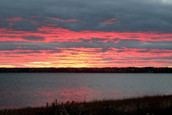 an image of a sun setting over a body of water